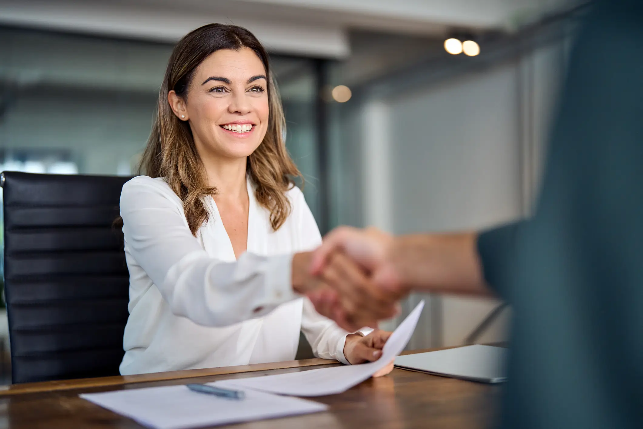 female solicitor shaking hands with another person at her desk