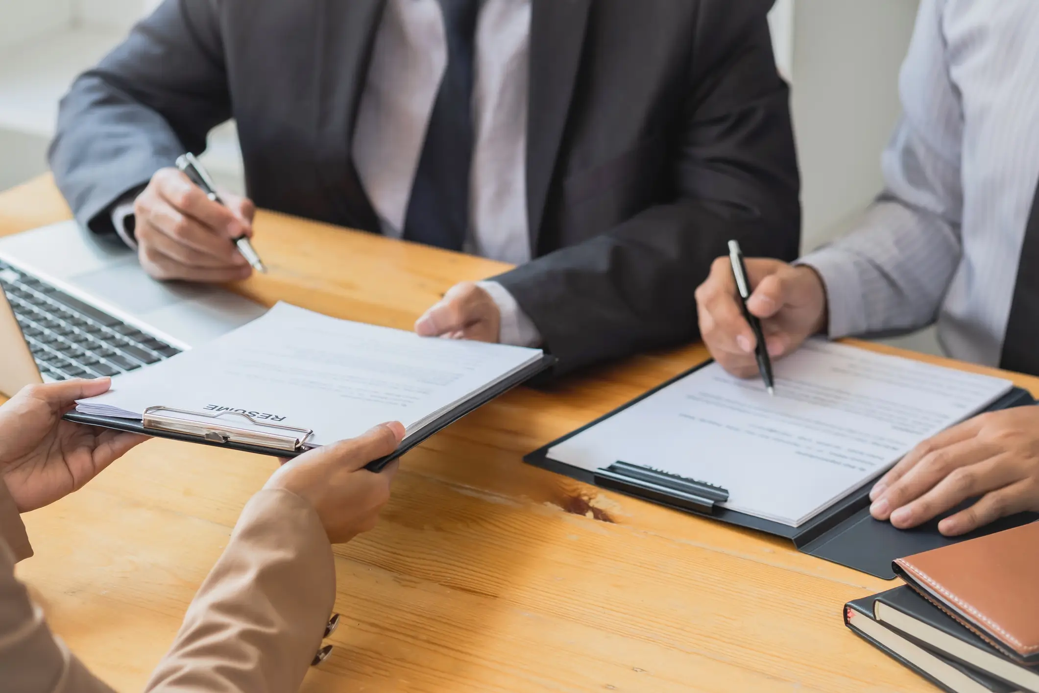 group of people sat at a table discussing legal documents