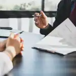 two people drawing up a settlement agreement contract